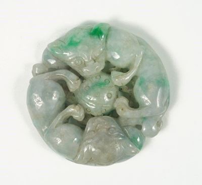 Fermacarte circolare in giadeite scolpita con motivi di animali fantastici, Cina, XX secolo